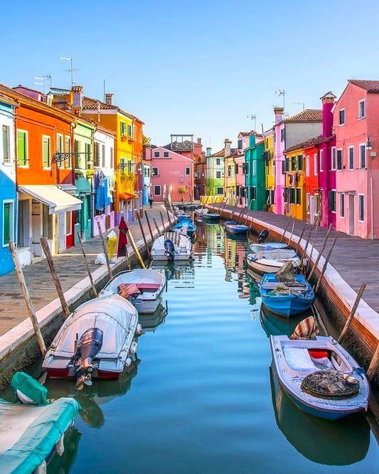 Colorful buildings and boats along a canal in Burano, Italy