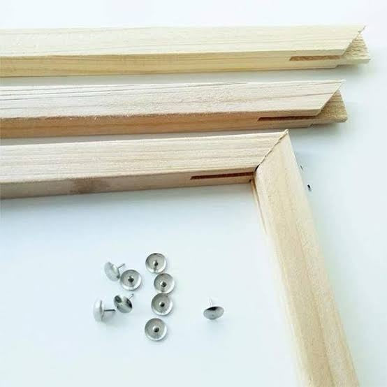 Wooden picture frame components and screws on a white background