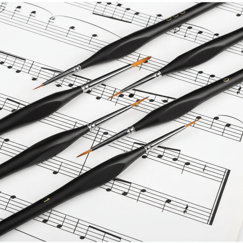 Set of black paintbrushes on a sheet of music