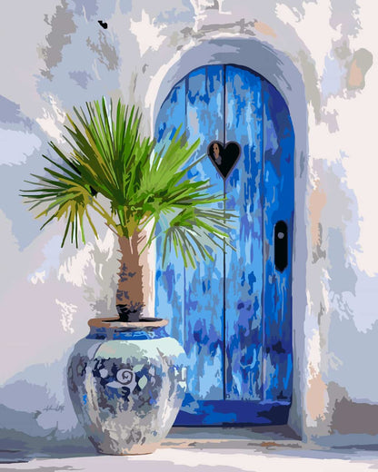 A paint by number of a bright blue arched wooden door with a heart-shaped window and black handle, set in a white stucco wall beside a potted green palm in a blue-and-white ceramic pot.