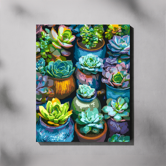 A vertical paint by number canvas featuring a colorful, stylized painting of various succulent plants in pots, displayed on a light gray wall with soft shadows.