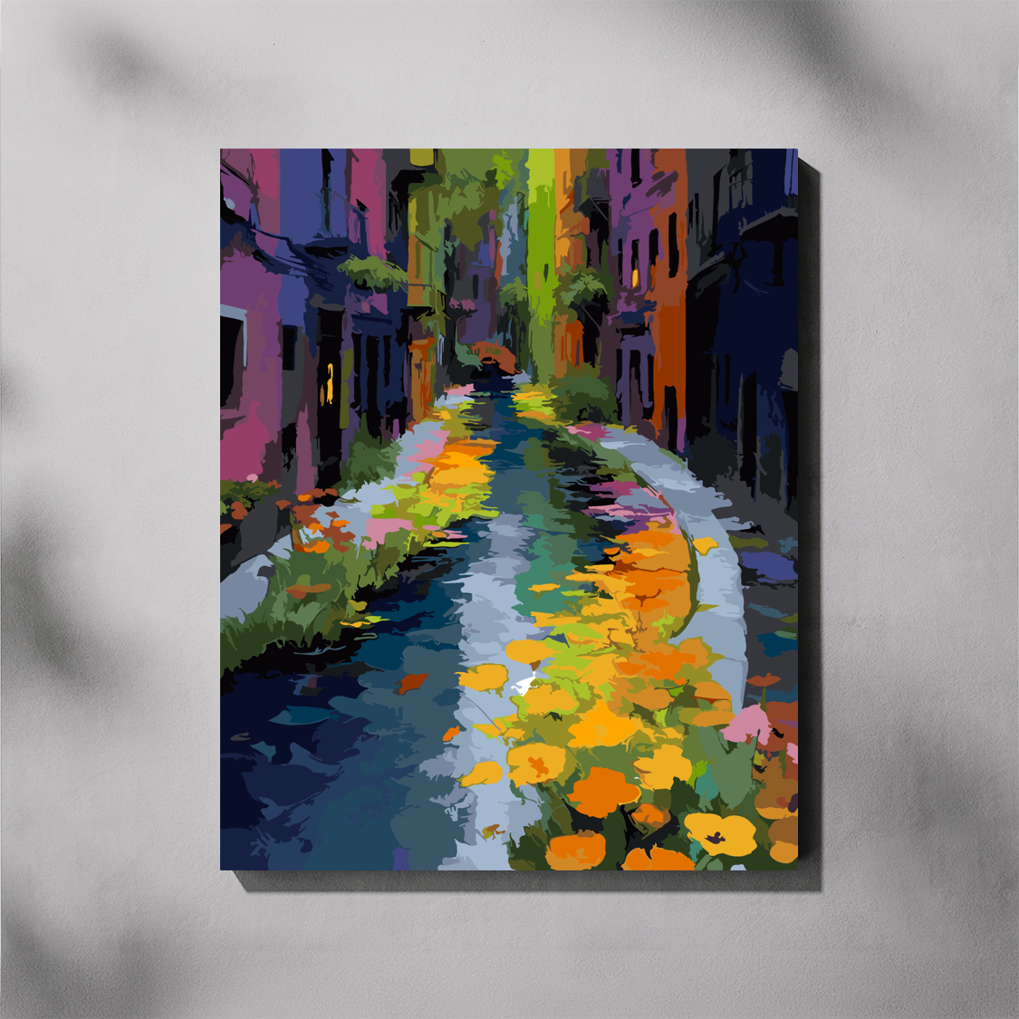 A vertical paint by number canvas of a colorful, impressionistic street scene with vibrant buildings and flowers, displayed on a light gray wall with soft shadows.