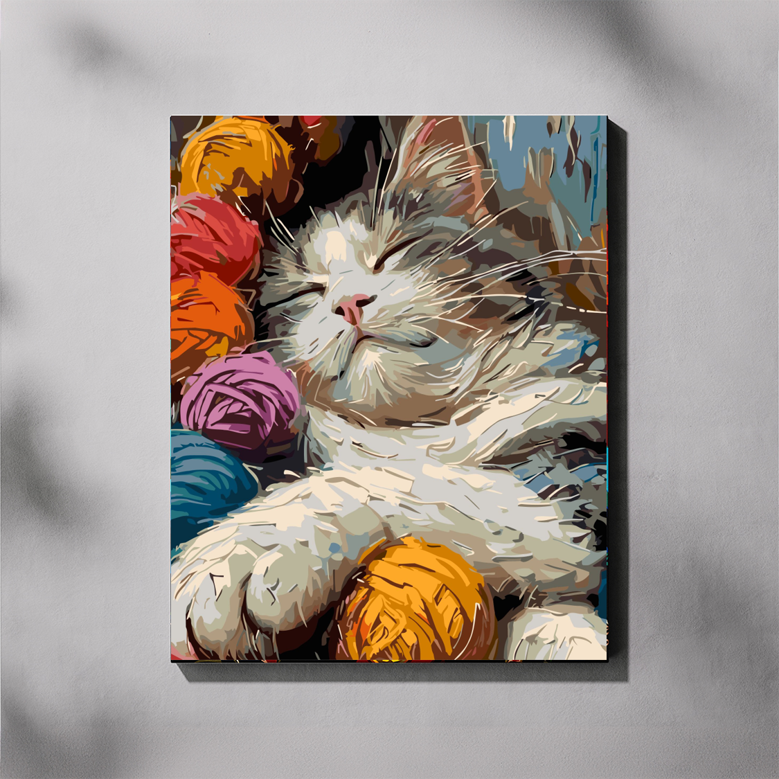 Canvas print of a cat surrounded by colorful yarn balls on a gray background