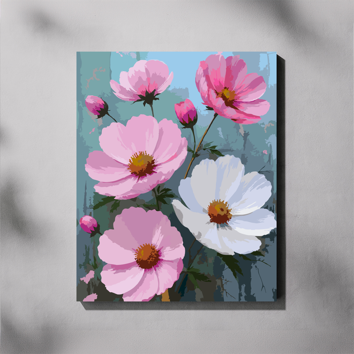 A completed paint by number canvas featuring a display of cosmos flowers in shades of pink and white  with yellow centers against a muted blue-gray background, shown hanging on a light gray wall.