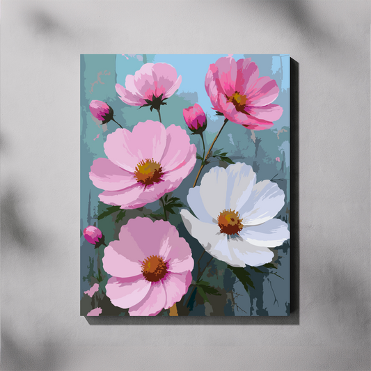 A completed paint by number canvas featuring a display of cosmos flowers in shades of pink and white  with yellow centers against a muted blue-gray background, shown hanging on a light gray wall.