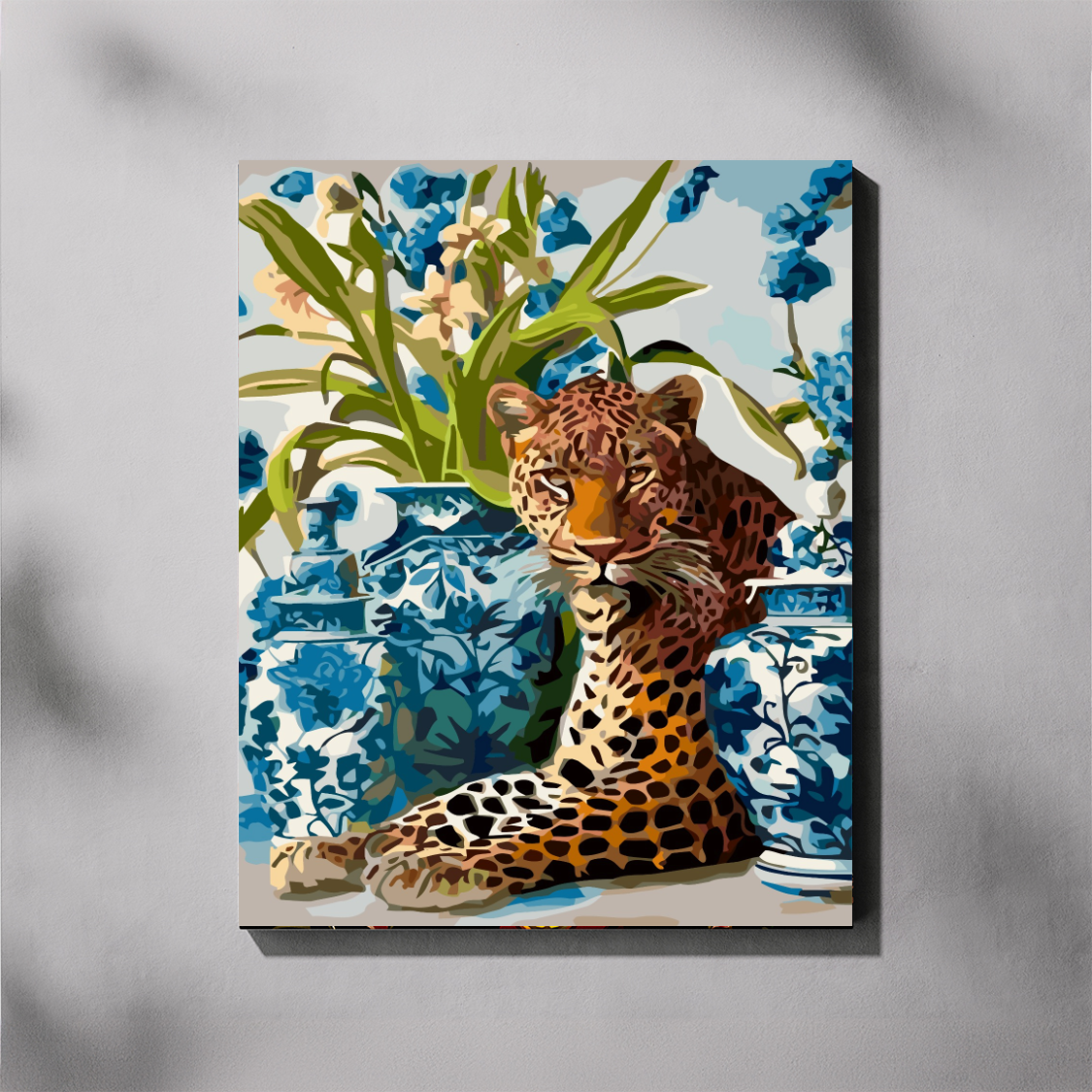 Delft Leopard paint by number kit — completed canvas mockup of a leopard draped among blue and white Delft vases and tall blue and cream orchid flowers
