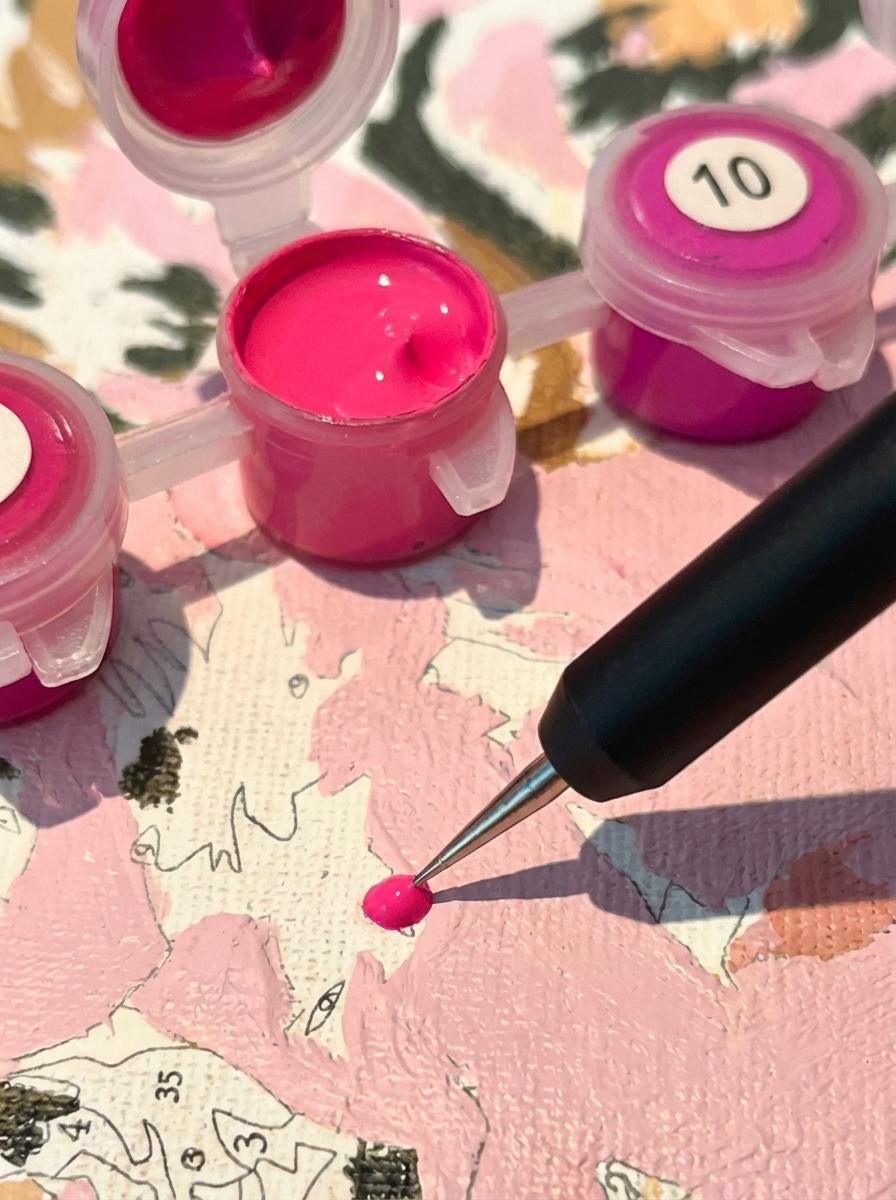 Pink paint with a dotting pen on a colorful canvas background