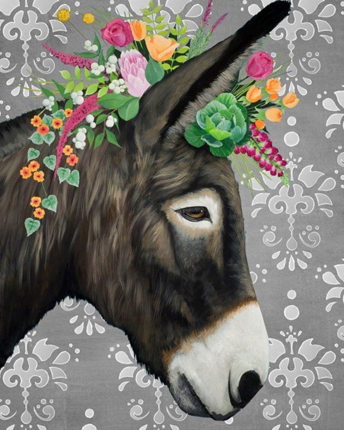 A close-up portrait of a dark brown donkey head with a white muzzle, decorated with a colorful floral crown of pink, orange, yellow, and green flowers, set against a gray damask-patterned background.