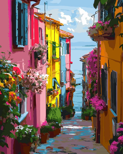 Vibrant paint by number of a narrow coastal street lined with colorful houses in pink, yellow, orange, and blue, decorated with abundant flowering plants and overlooking the sea under a bright sky.