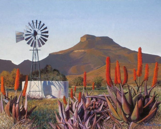 Windmill with mountains and red plants in the background