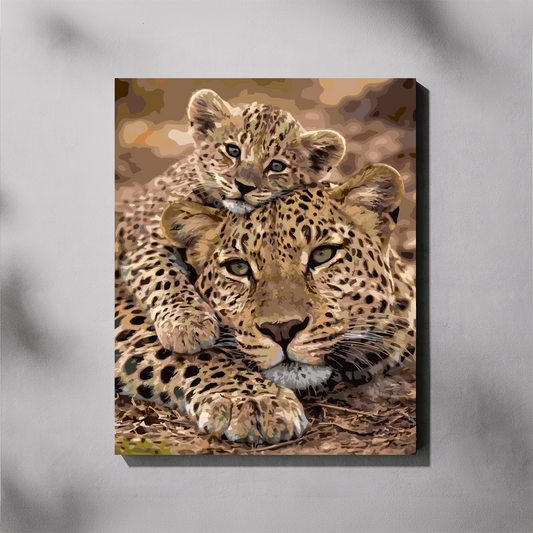 A vertical canvas paint by number depicting a leopard mother and cub resting together, shown hanging on a light gray wall with soft shadow overlays.