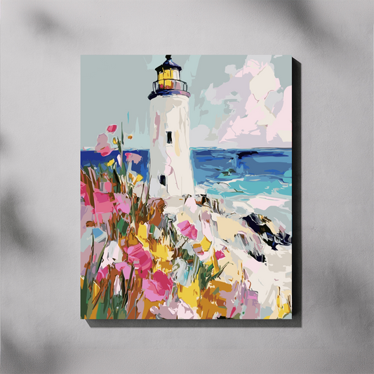 A vertical paint by number canvas of a lighthouse on a rocky shoreline with colorful wildflowers, shown hanging on a light gray wall with soft shadow overlays.
