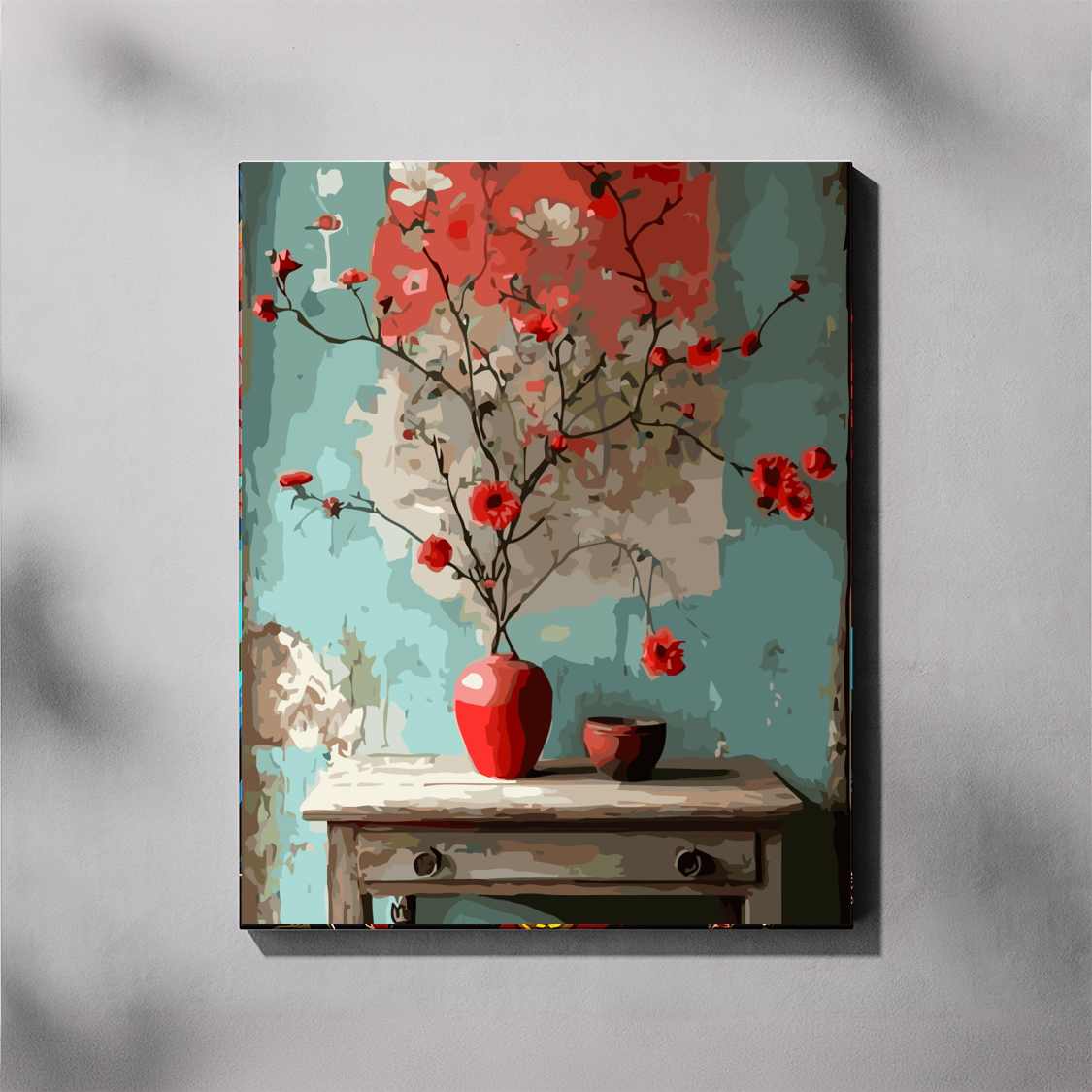 Canvas print of a floral scene with red flowers and a red vase on a wooden table against a textured gray background.