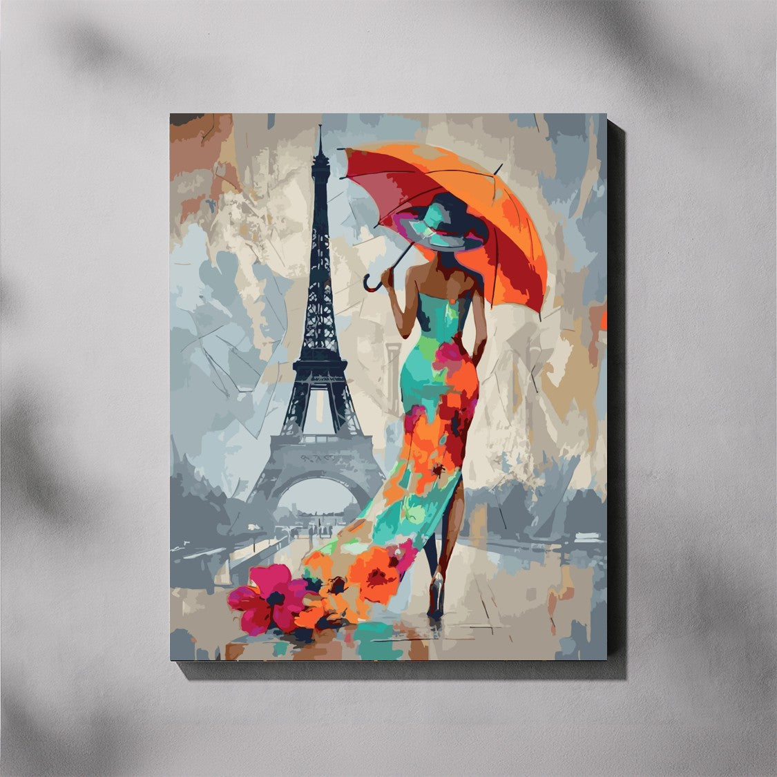 Canvas print of a woman in a colorful dress holding an orange umbrella with the Eiffel Tower in the background.