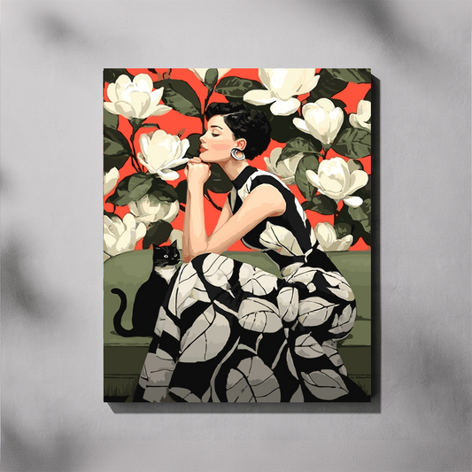 Pondering Life paint by number kit — completed canvas mockup of a woman in a black and white leaf-print dress sitting on a sage green sofa smelling a white magnolia, with a black cat beside her and giant magnolias on a vivid red background
