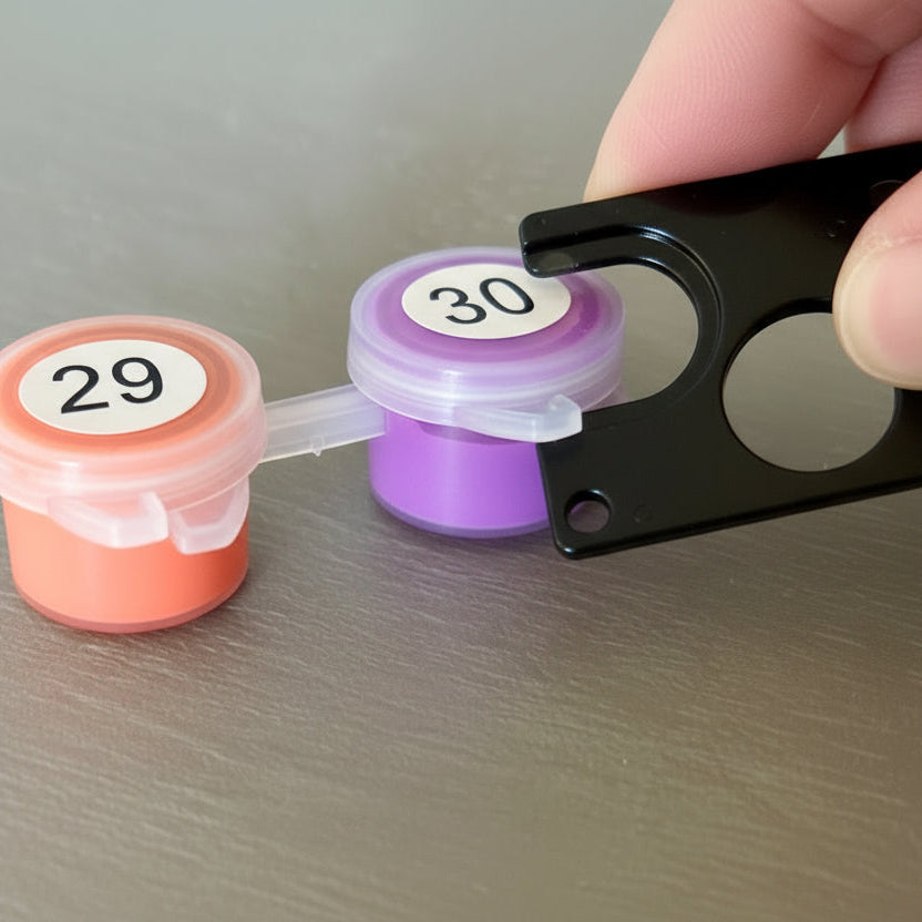 Two small containers with numbered labels and a black tool on a gray surface