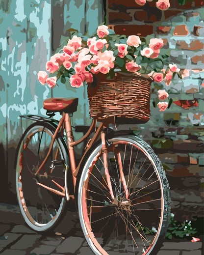 Bicycle with a basket full of pink flowers against a textured wall.