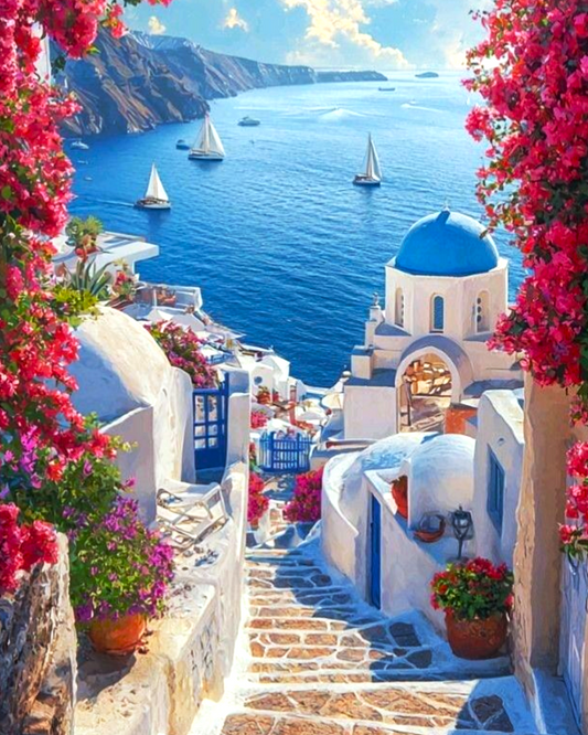 Scenic view of a coastal town with blue-domed churches and pink flowers in Santorini, Greece.
