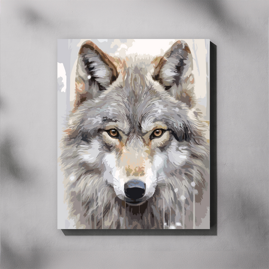 A paint by number canvas showing a close-up painted portrait of a gray wolf with amber eyes, displayed against a light gray wall with soft shadow overlays.