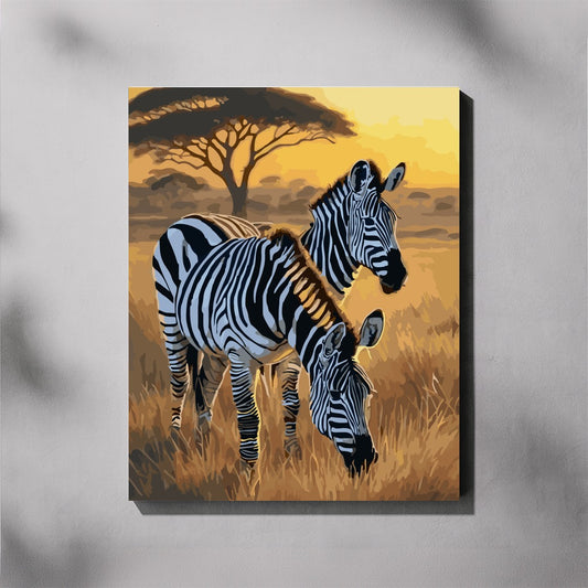 Canvas print of two zebras in a savannah landscape with a sunset.