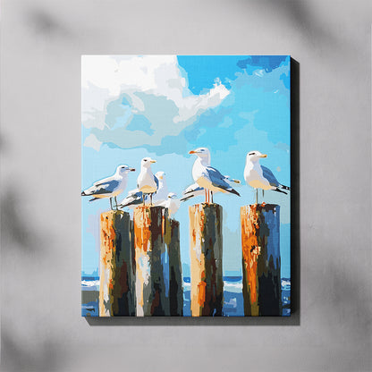 Canvas print of seagulls on wooden posts with a blue sky and ocean background.