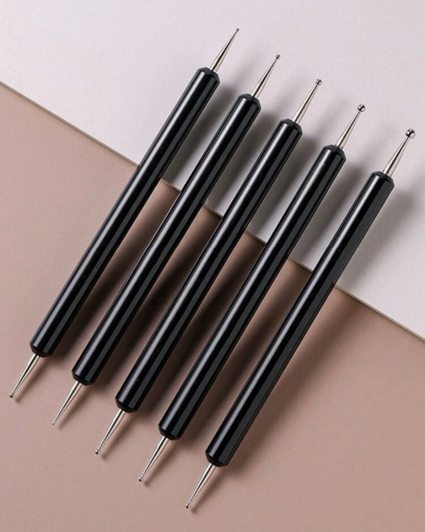 Set of black tools with pointed ends on a beige and white background