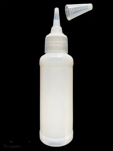 White plastic bottle with a nozzle on a black background