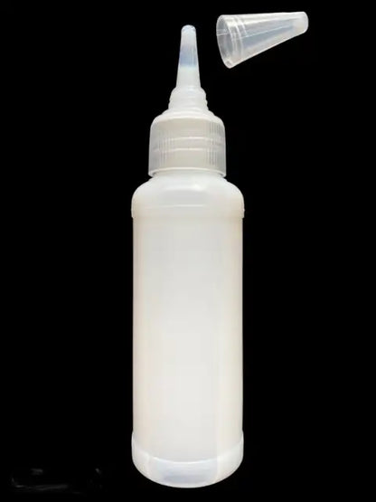 White plastic bottle with a nozzle on a black background