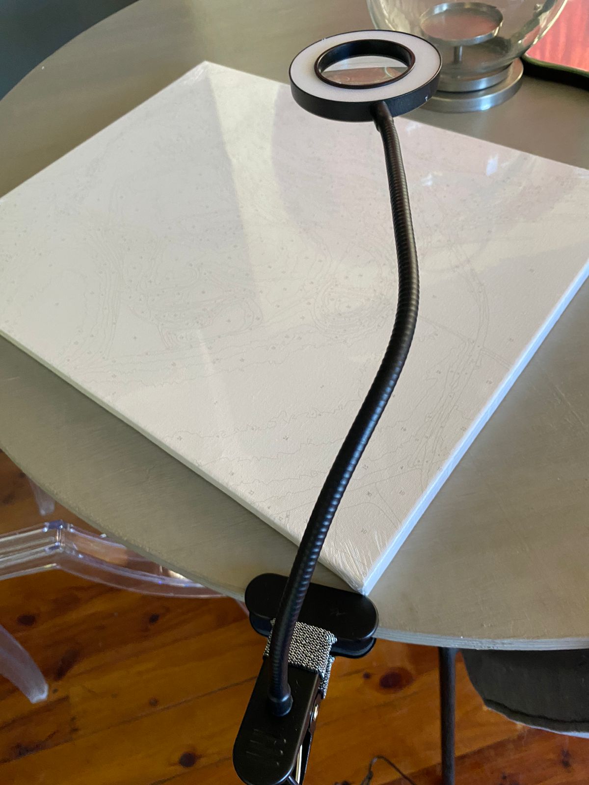 Black flexible arm with a clip on a white surface