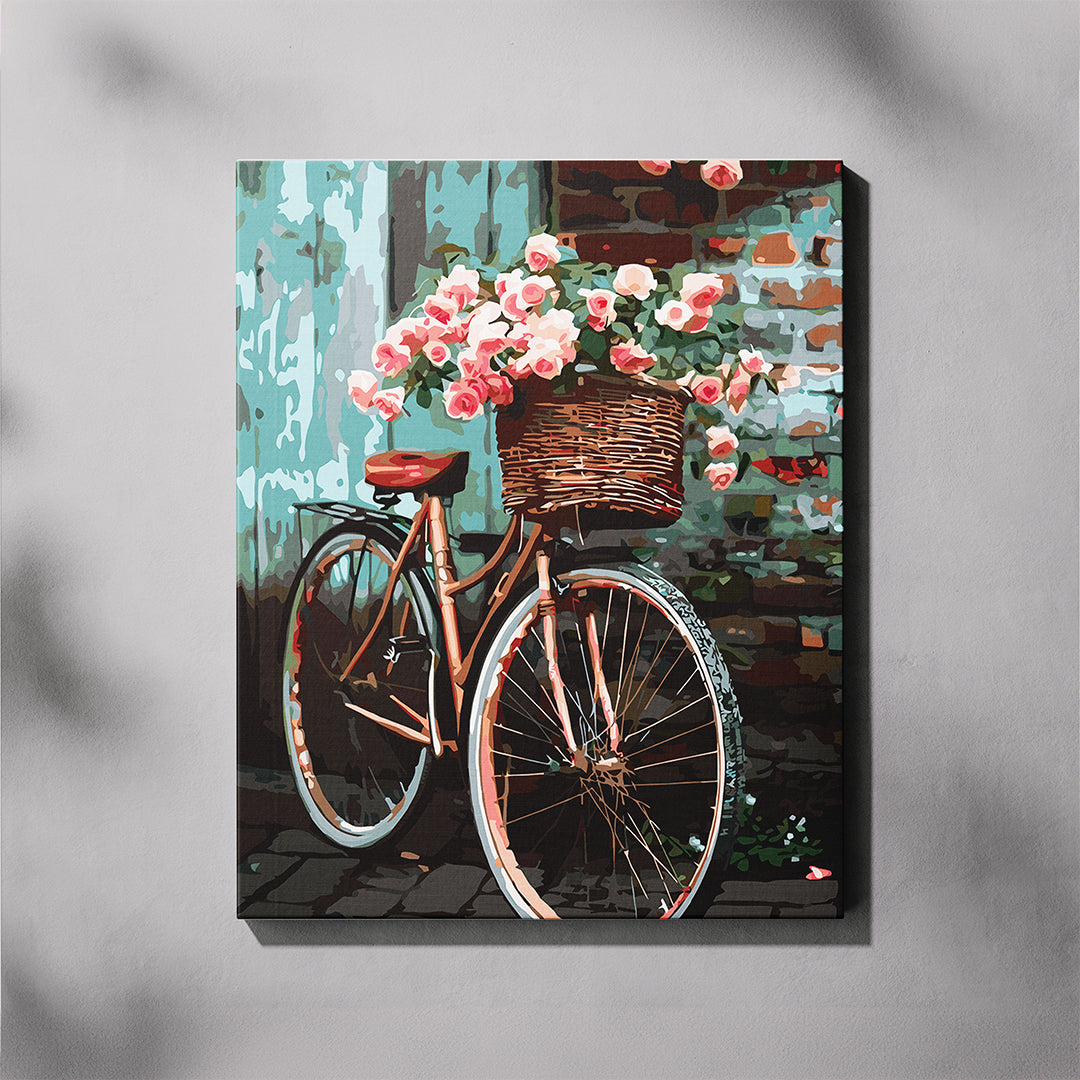 Canvas print of a bicycle with a flower basket against a brick wall.