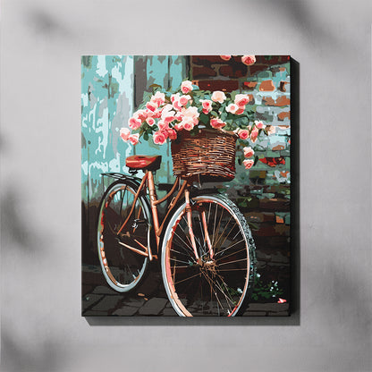 Canvas print of a bicycle with a flower basket against a brick wall.