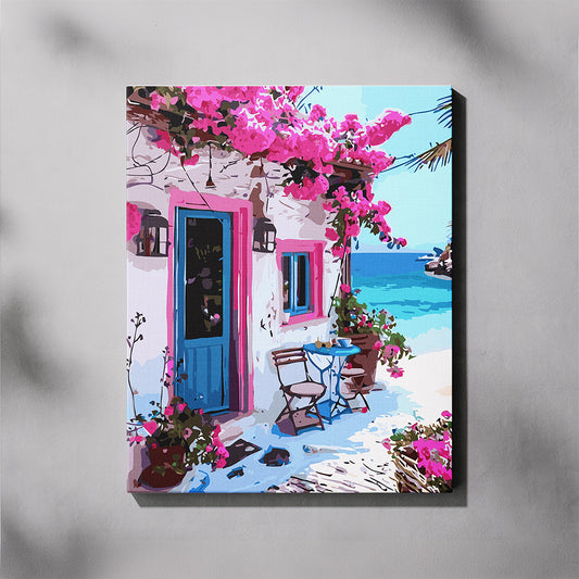 Colorful painting of a Mediterranean scene with a house, blue door, and pink flowers.