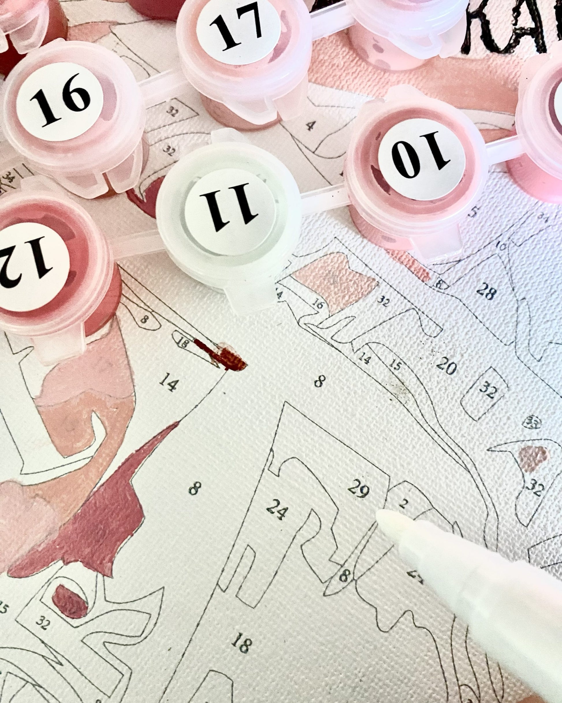 Pink number stamps with white numbers on a paper with printed patterns and measurements.